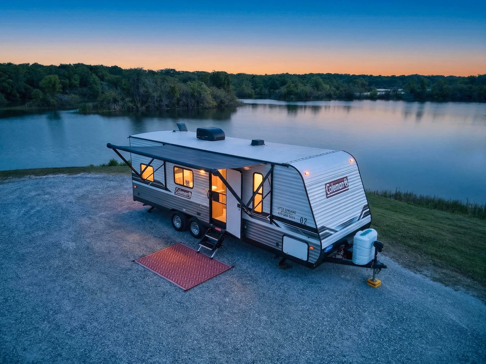 Little Sunshine travel trailer set up beside a Florida lake at sunset